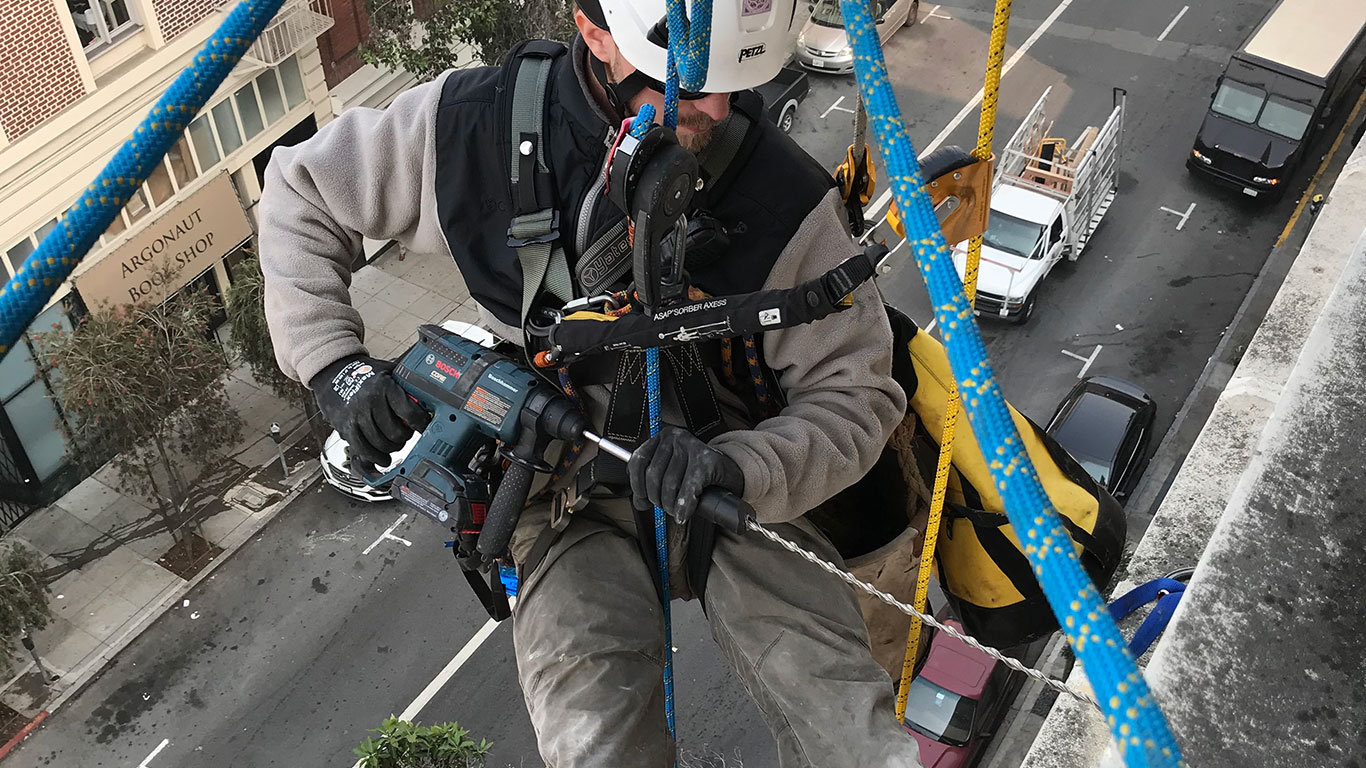 Rope access technician driving a Helifix pin